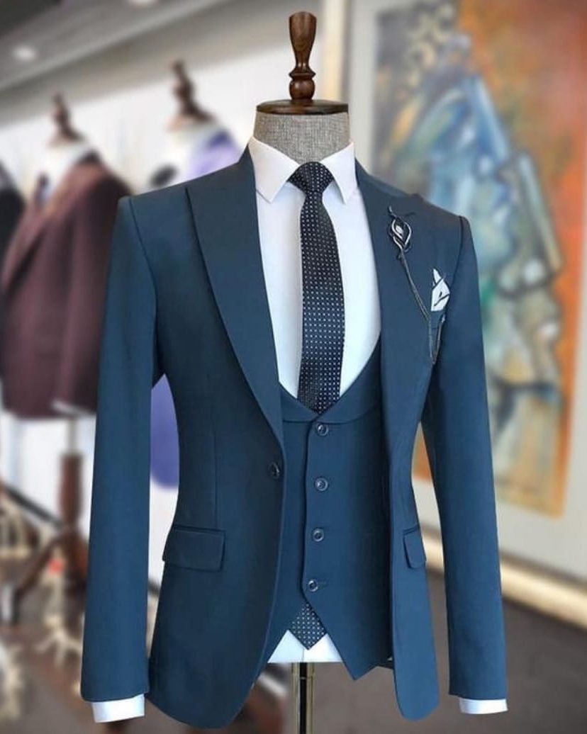 Teal suit on display in front of a rack of house colours at Blaze Suits