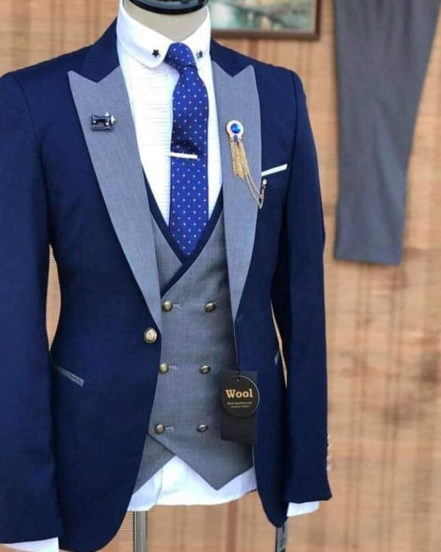 Navy suit with grey double-breasted waistcoat and lapel brooch