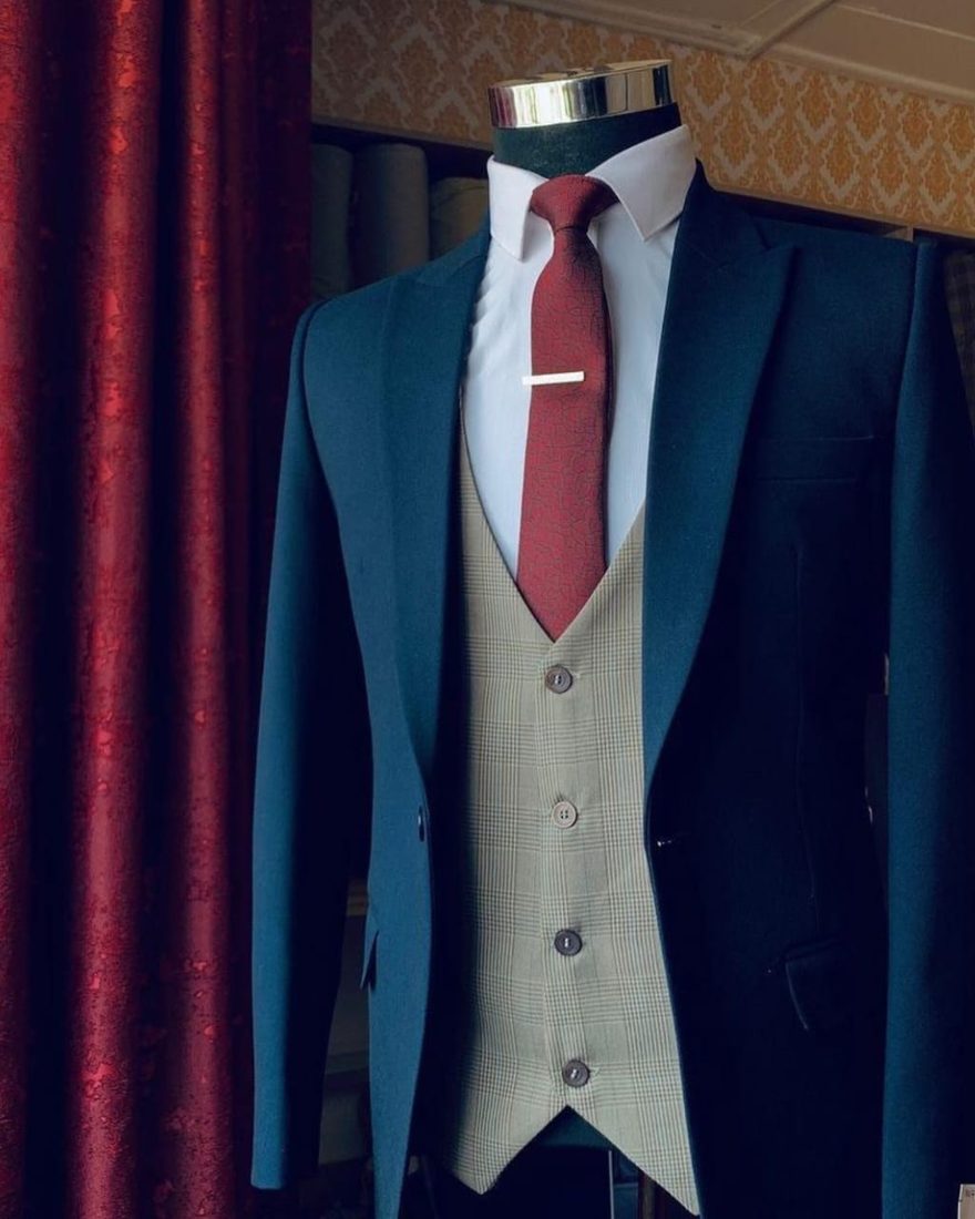 Teal suit jacket with checked waistcoat and burgundy tie